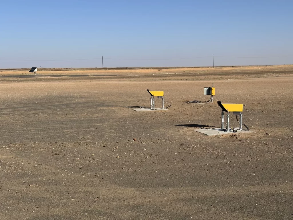 Two new yellow Solar Series LED PAPI units on galvanised stands with a control cabinet, on reused concrete foundations
