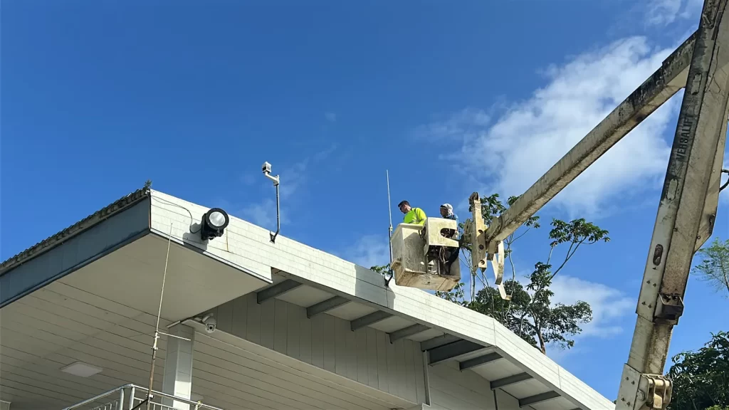 Aviation Renewables crew on a lift installing the MWS-C600 weather station and LIDAR ceilometer on a building roof