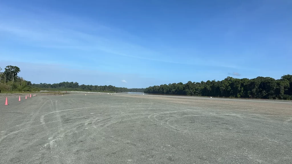 Remote gravel airstrip in South America lined by rainforest, site of a solar LED airfield lighting installation